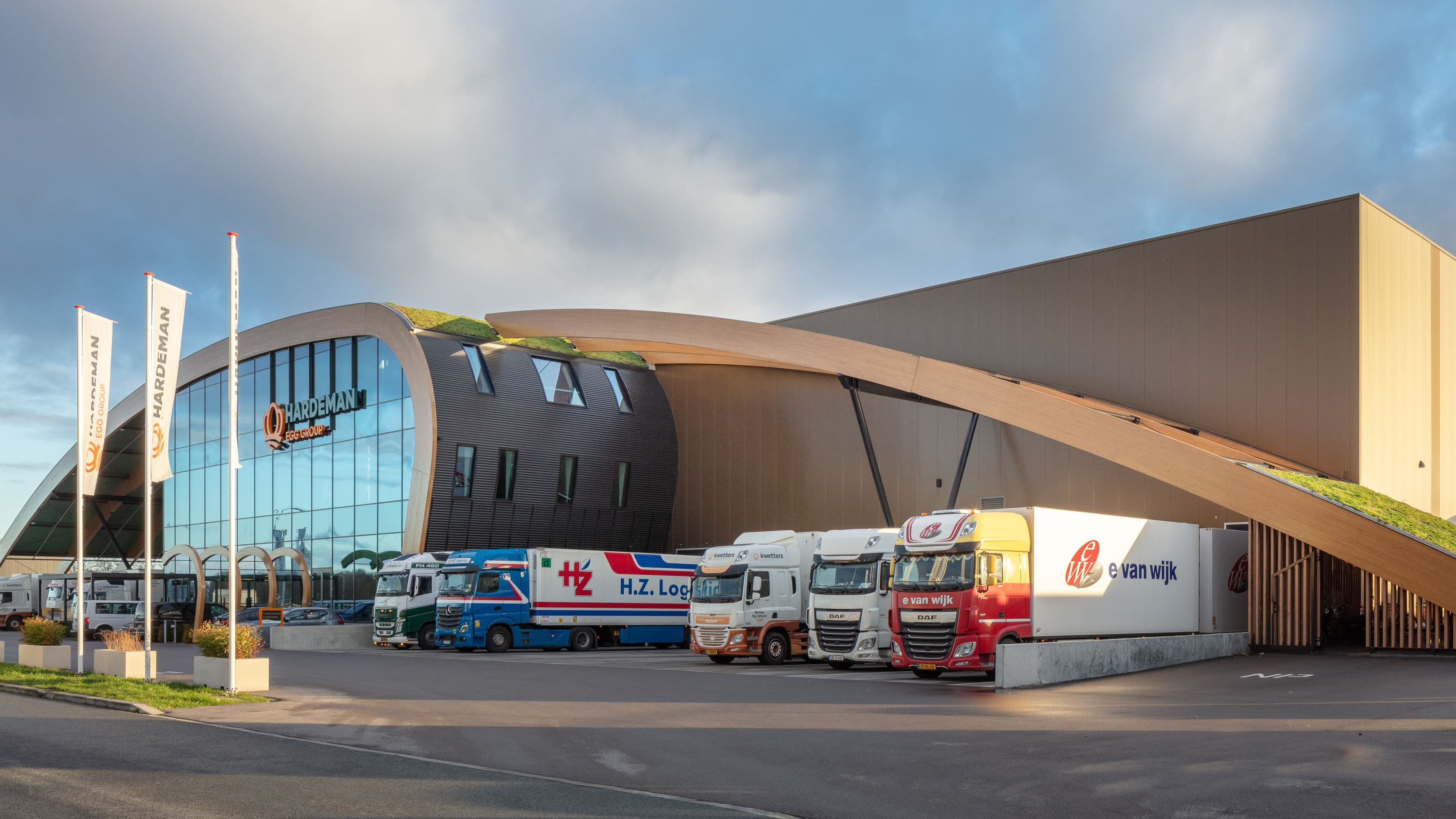 Modern distributiecentrum met laadperrons en vrachtwagens bij de entree – Hardeman Eggroup