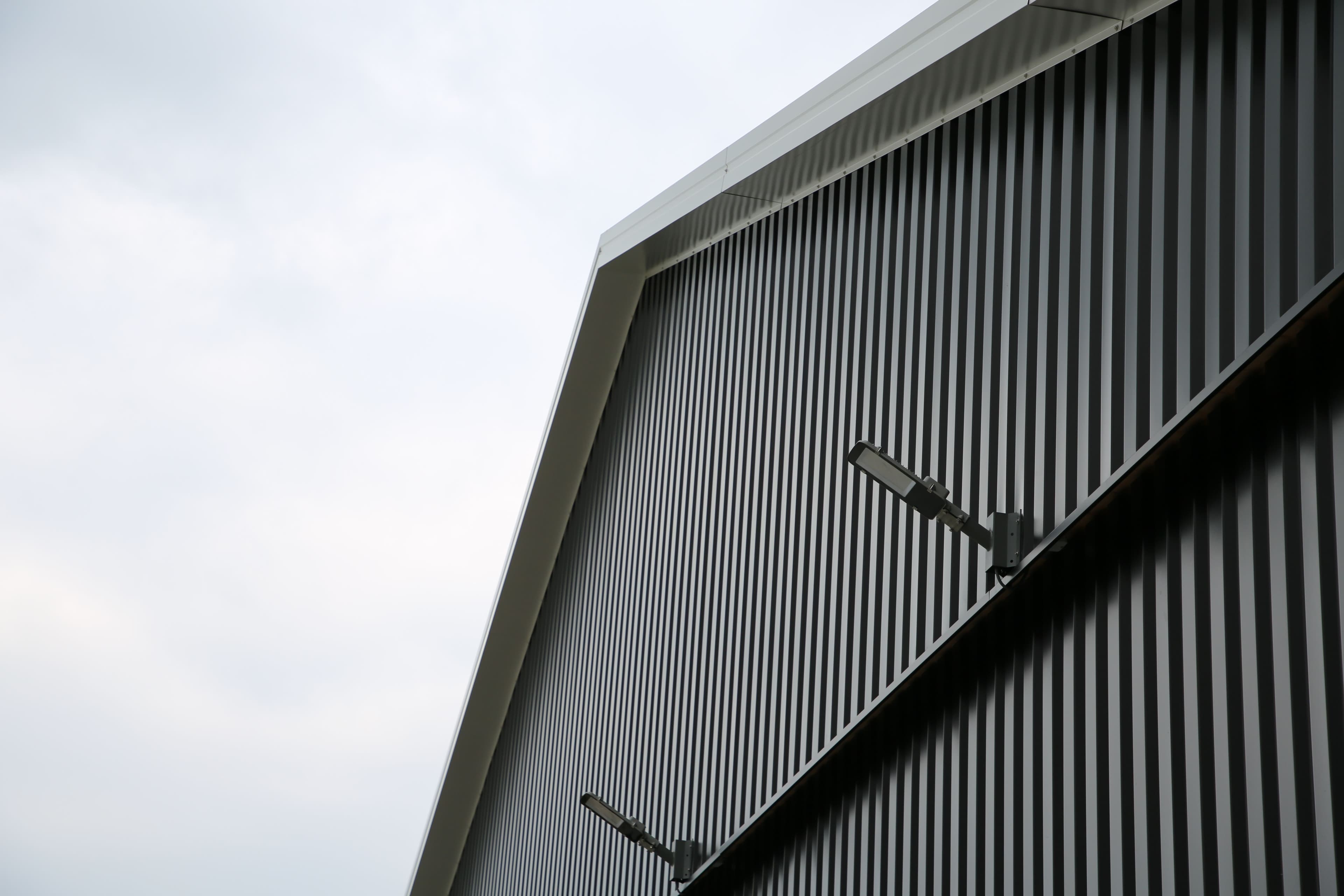 Detail van gevelrenovatie met verticale metalen gevelbeplating