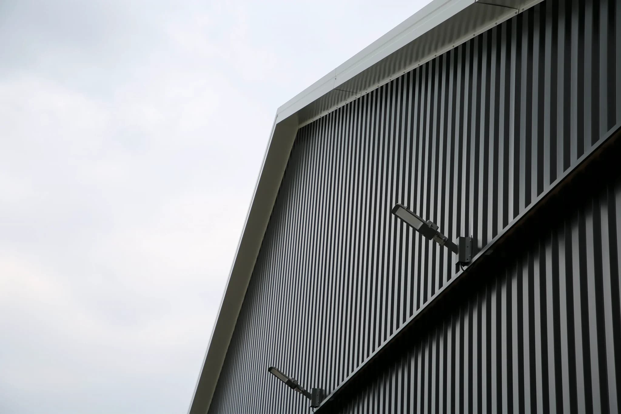 Detail van gevelrenovatie met verticale metalen gevelbeplating
