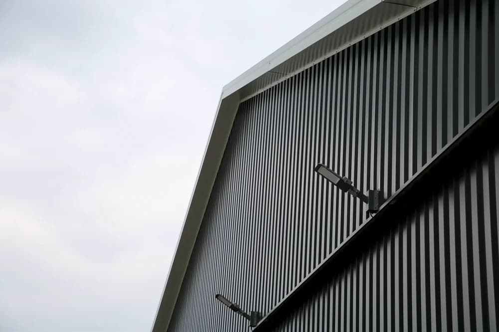 Detail van gevelrenovatie met verticale metalen gevelbeplating