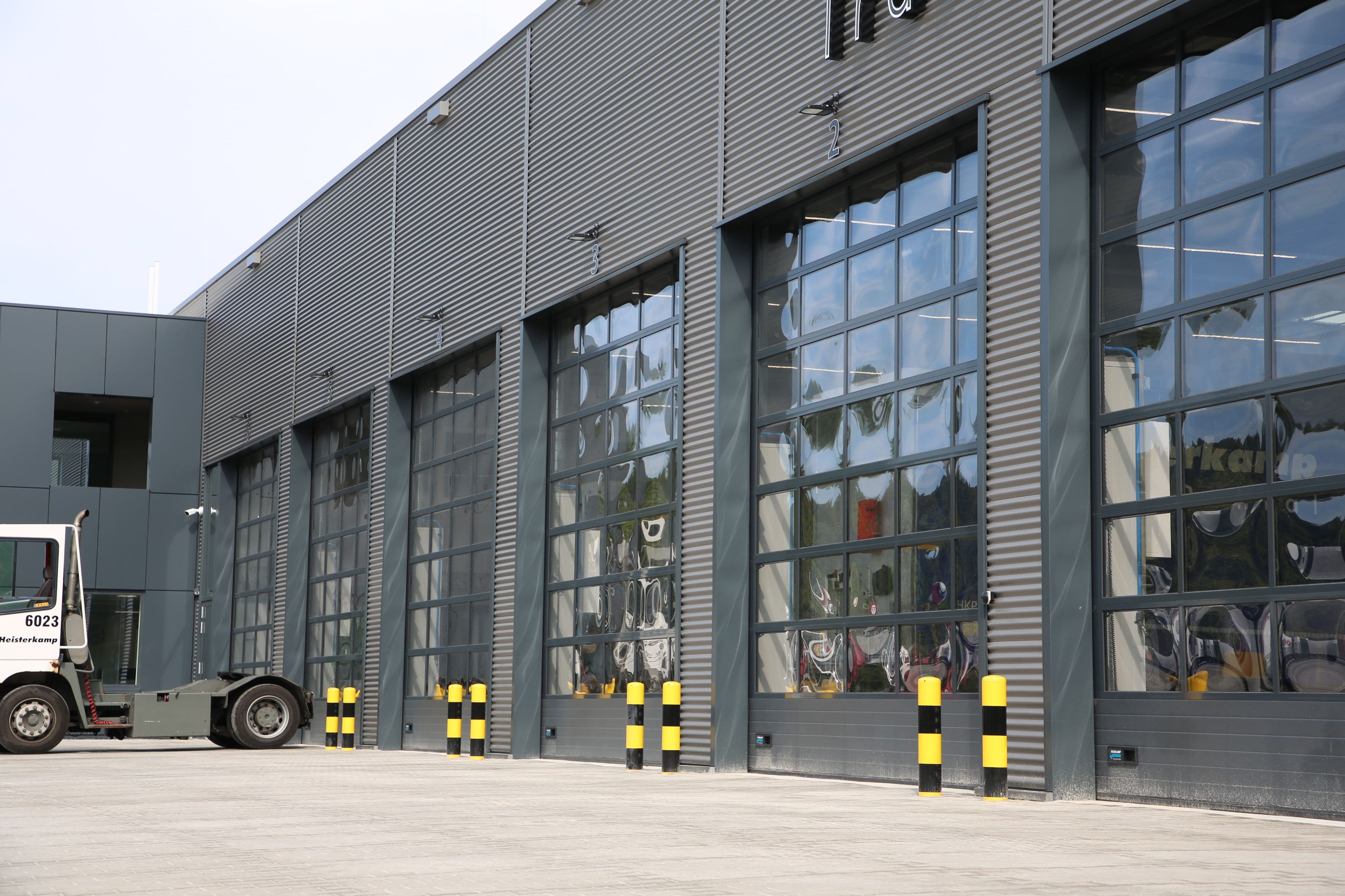 Bedrijfshal met metalen gevelbekleding en industriële overheaddeuren