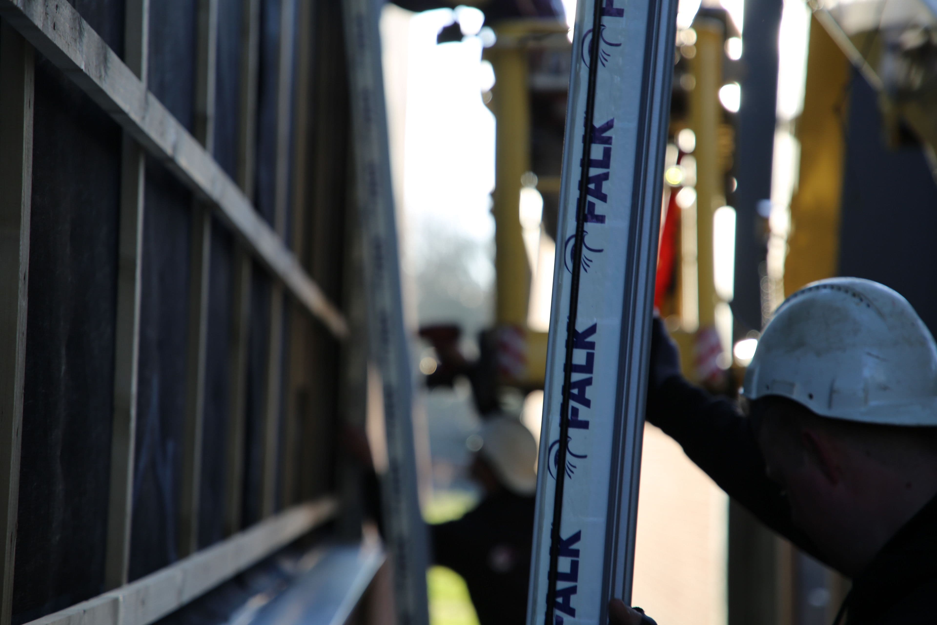 Monteur monteert sandwichpanelen aan de gevel van een bedrijfshal