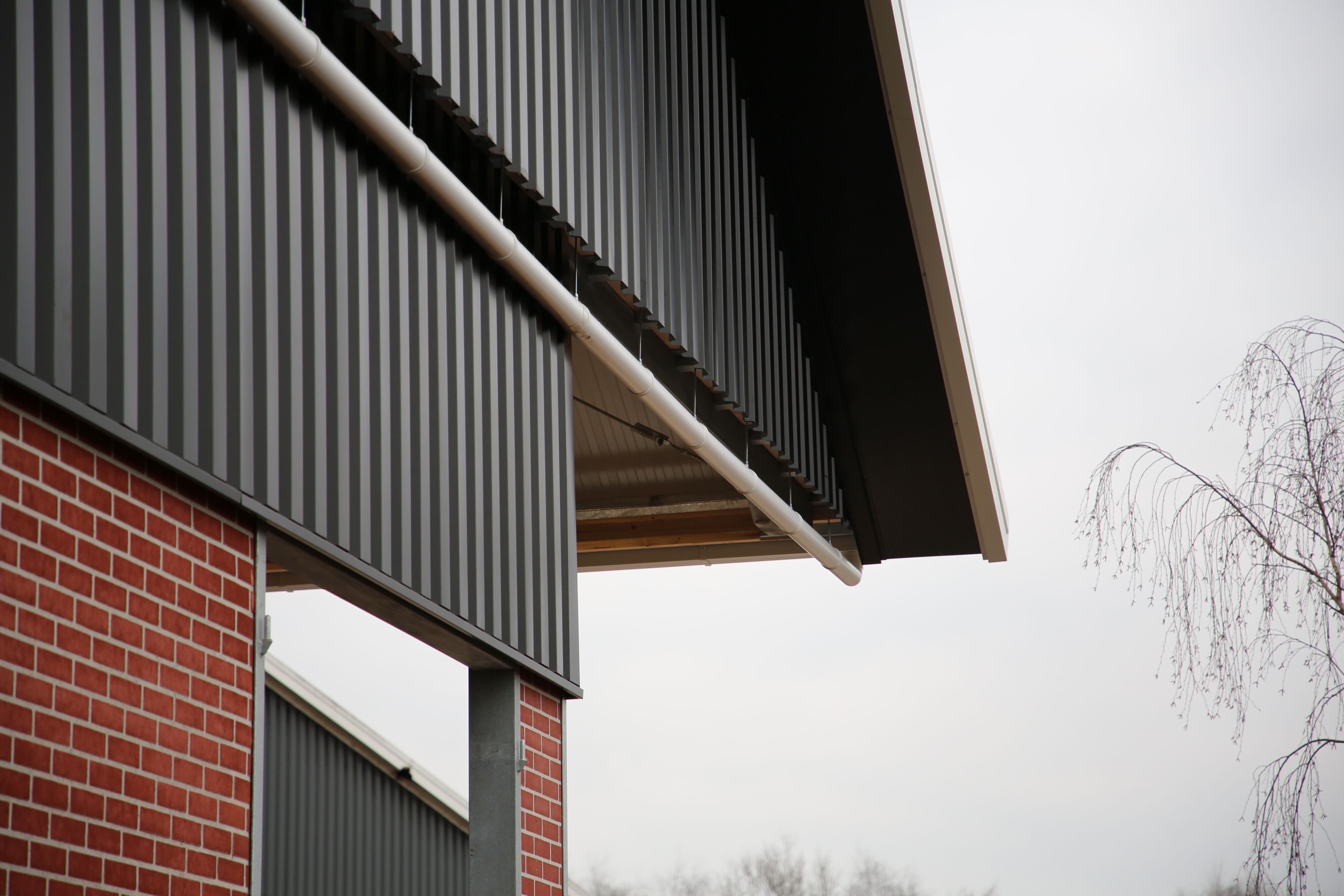 Dakrand en geveldetail van de jongveestal in Geesteren met stalen gevelbeplating