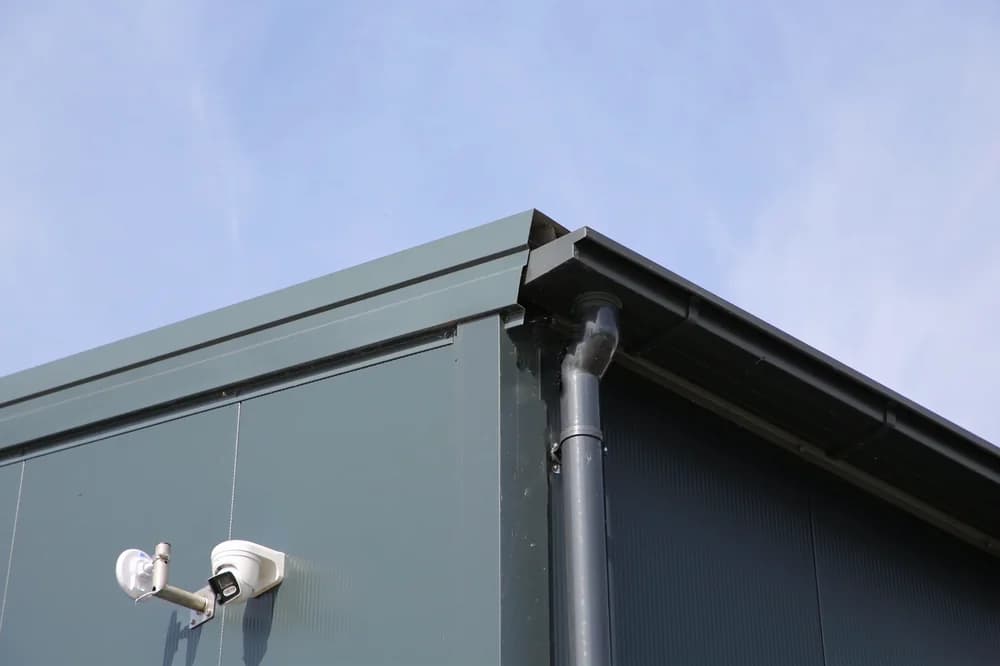 Detailfoto van een grijze gevel en dakrand van bedrijfshallen in Bemmel.
