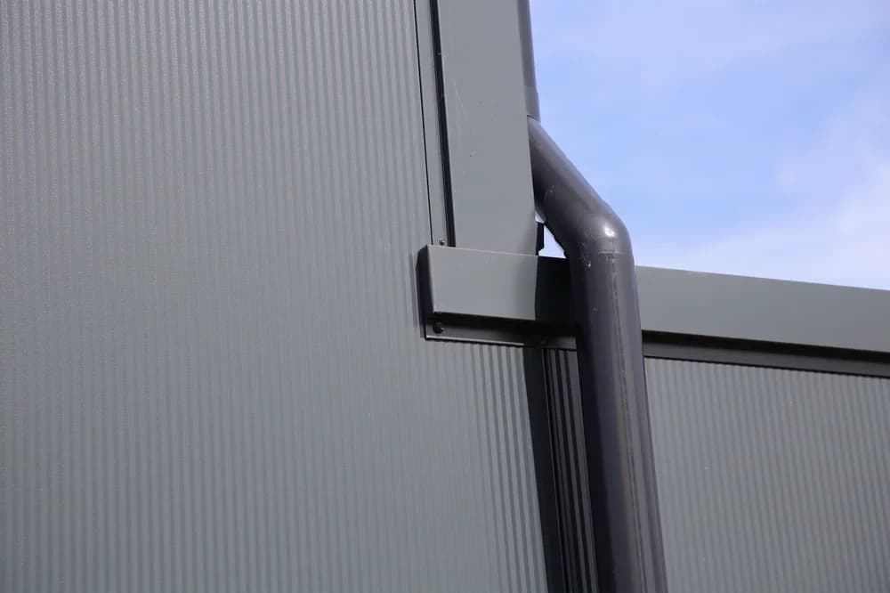 Detail van hemelwaterafvoer en gevelbekleding bij bedrijfshal in Bemmel
