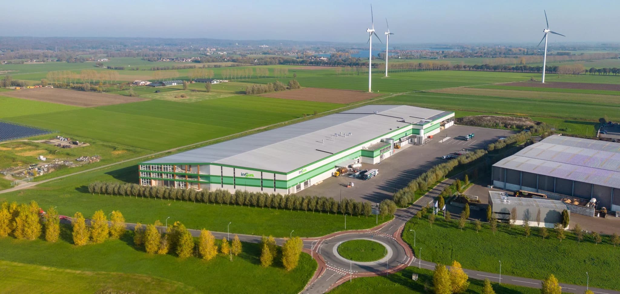 Luchtfoto van modern bedrijfspand met zonnepanelen op het dak in een landelijk gebied