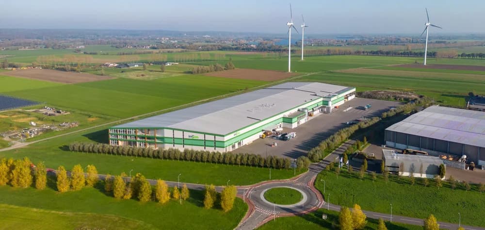 Luchtfoto van modern bedrijfspand met zonnepanelen op het dak in een landelijk gebied
