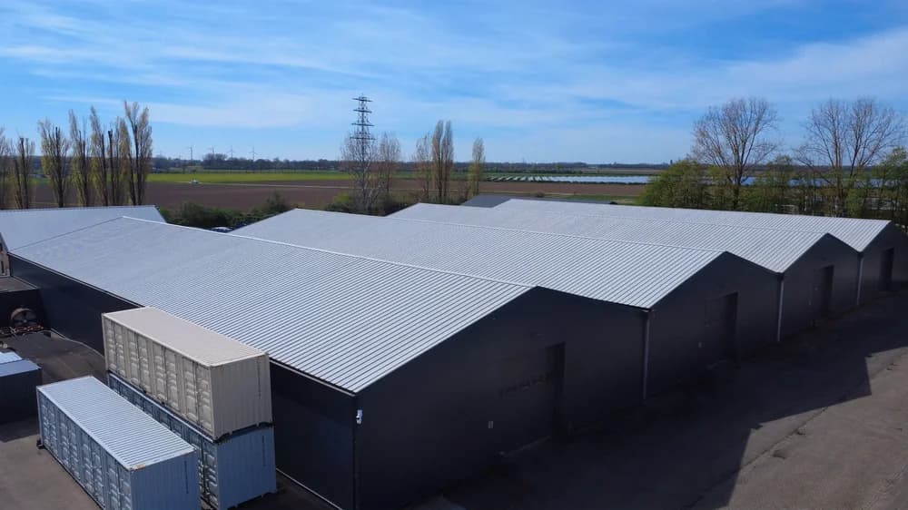 Bedrijfshallen in Bemmel met grijze gevels en lichte dakbekleding, gezien vanaf de achterzijde.
