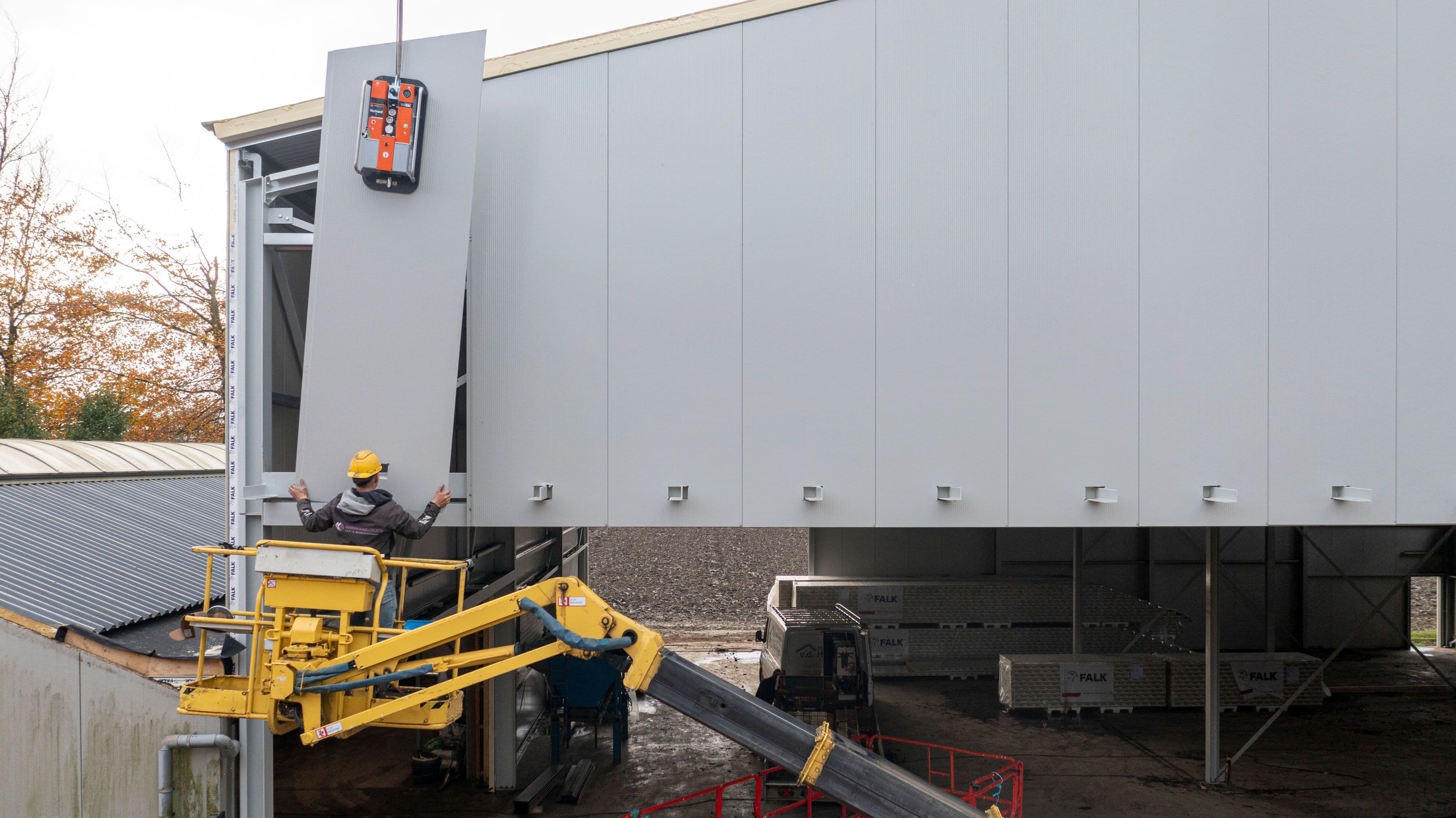 Montage van nieuwe gevelpanelen bij gevelrenovatie van bedrijfspand