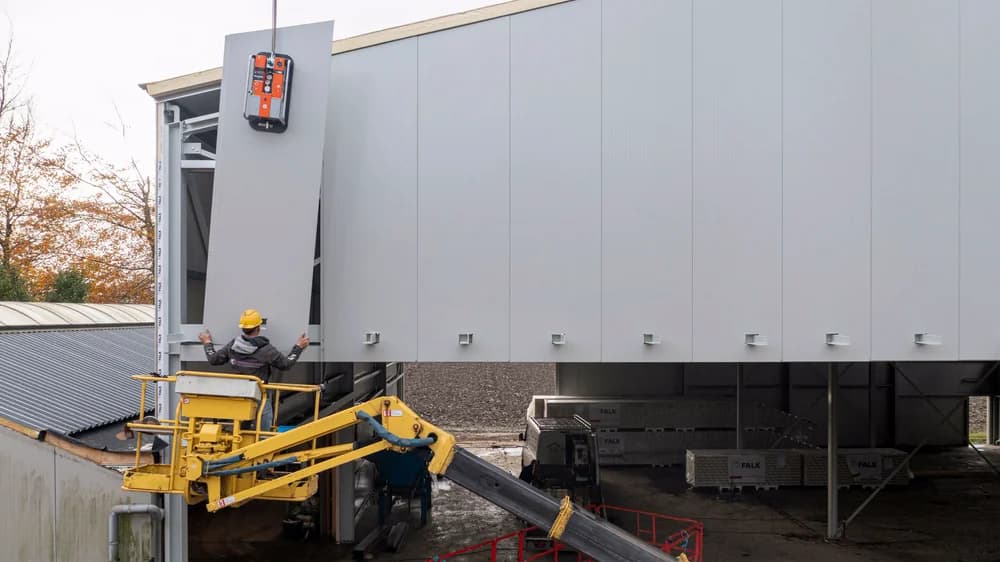 Montage van nieuwe gevelpanelen bij gevelrenovatie van bedrijfspand