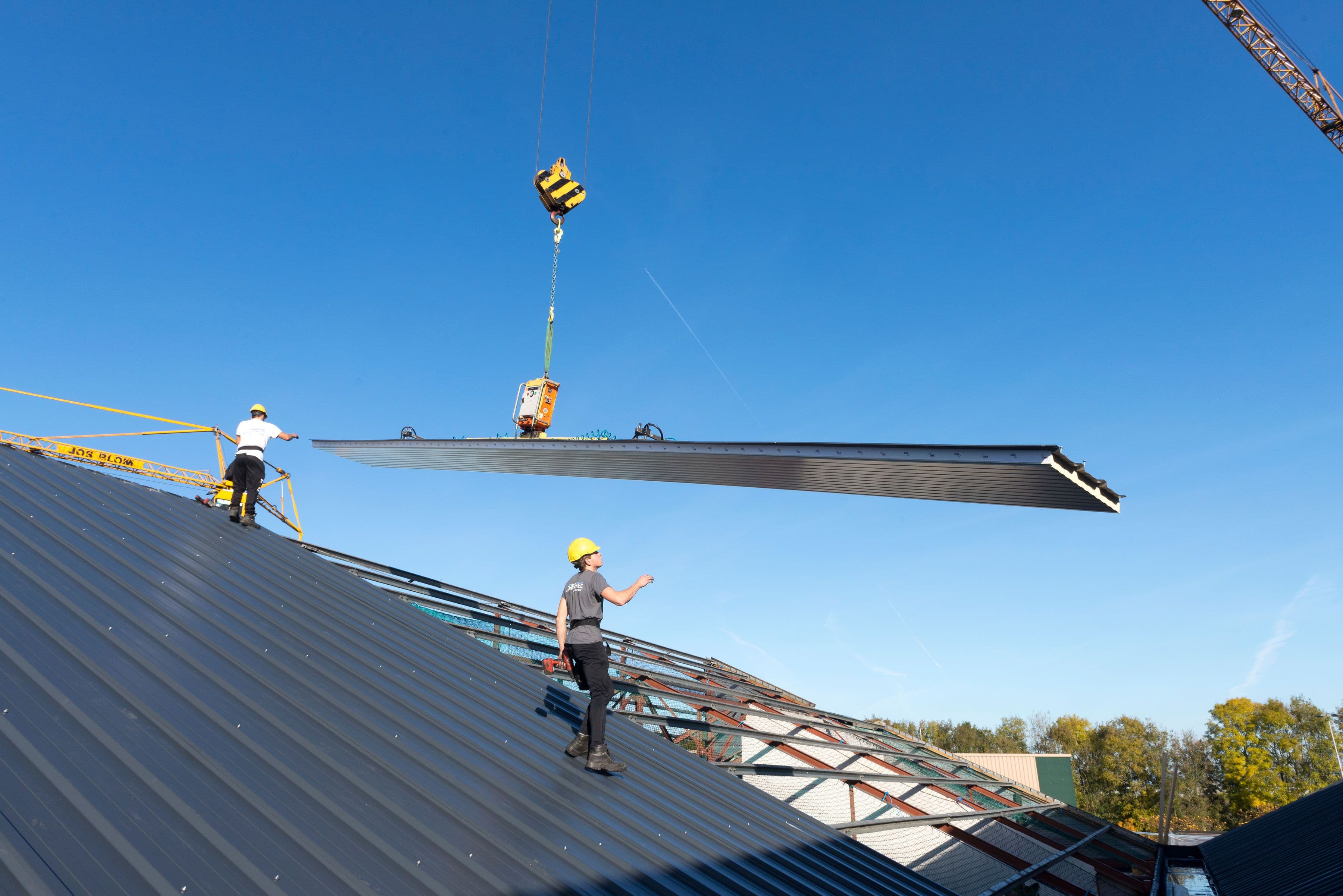 Dakrenovatie van bedrijfshal met montage van sandwichpanelen