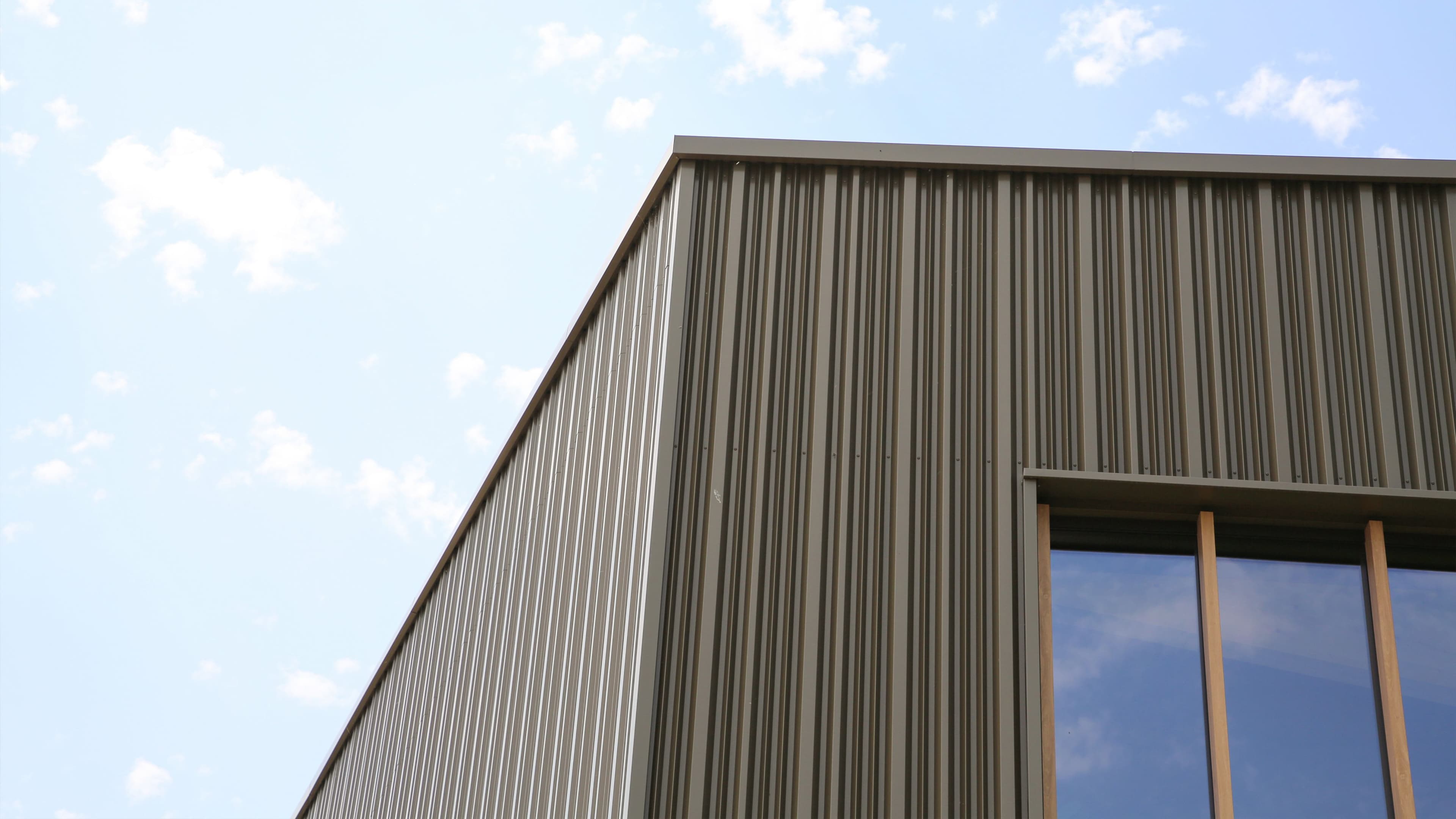 Gevel van het nieuwe bedrijfspand van Stabo Bouw in Zwaag met verticale designprofielen