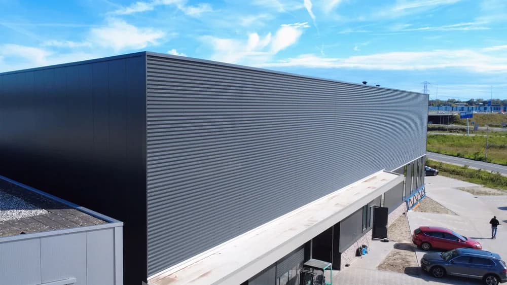 Geïsoleerde wandpanelen aan buitengevel van moderne bedrijfshal in Almere