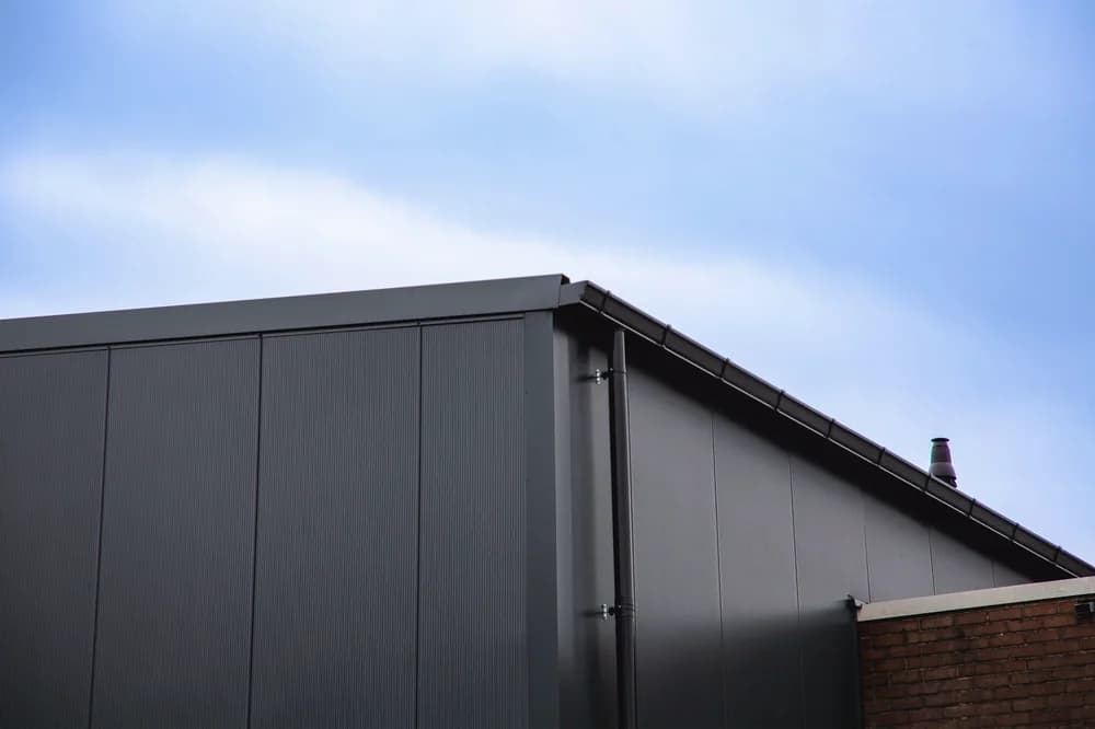 Nieuwe geïsoleerde dak- en gevelbeplating van een bedrijfshal aan de Hermesweg in Baarn, gerealiseerd door Hardeman Isolatie.