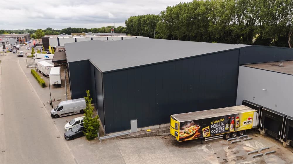 Schuine dronefoto van de gerenoveerde bedrijfshal aan de Hermesweg in Baarn met nieuwe dak- en gevelbeplating door Hardeman Isolatie.