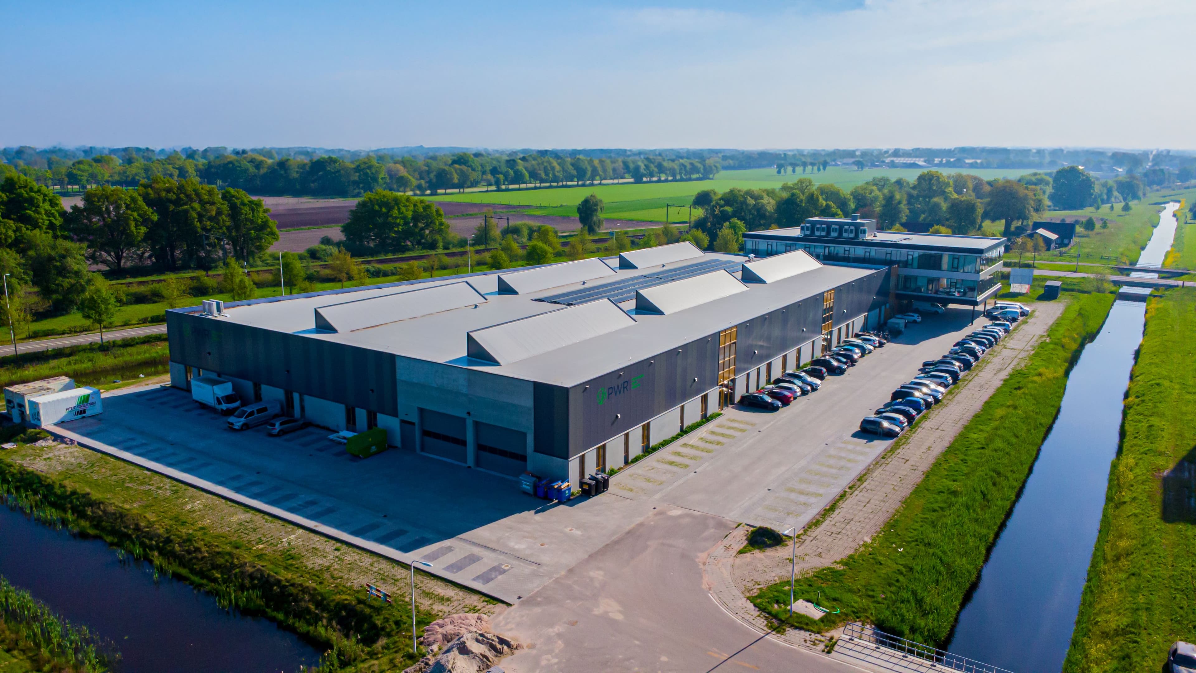 Nieuwbouw bedrijfspand van PWR Pack in Ede met laadzone en moderne gevel