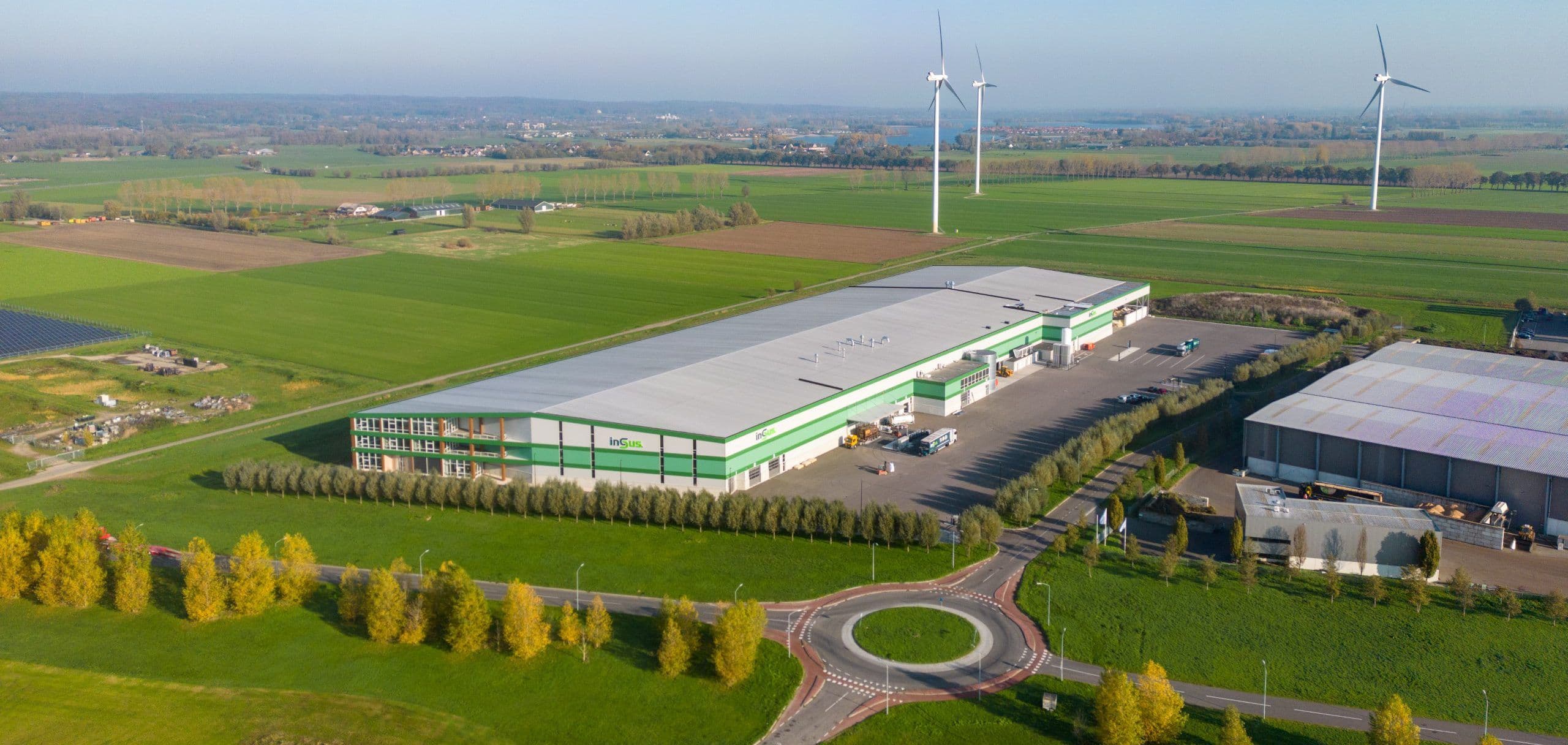 Luchtfoto van modern bedrijfspand met zonnepanelen op het dak in een landelijk gebied