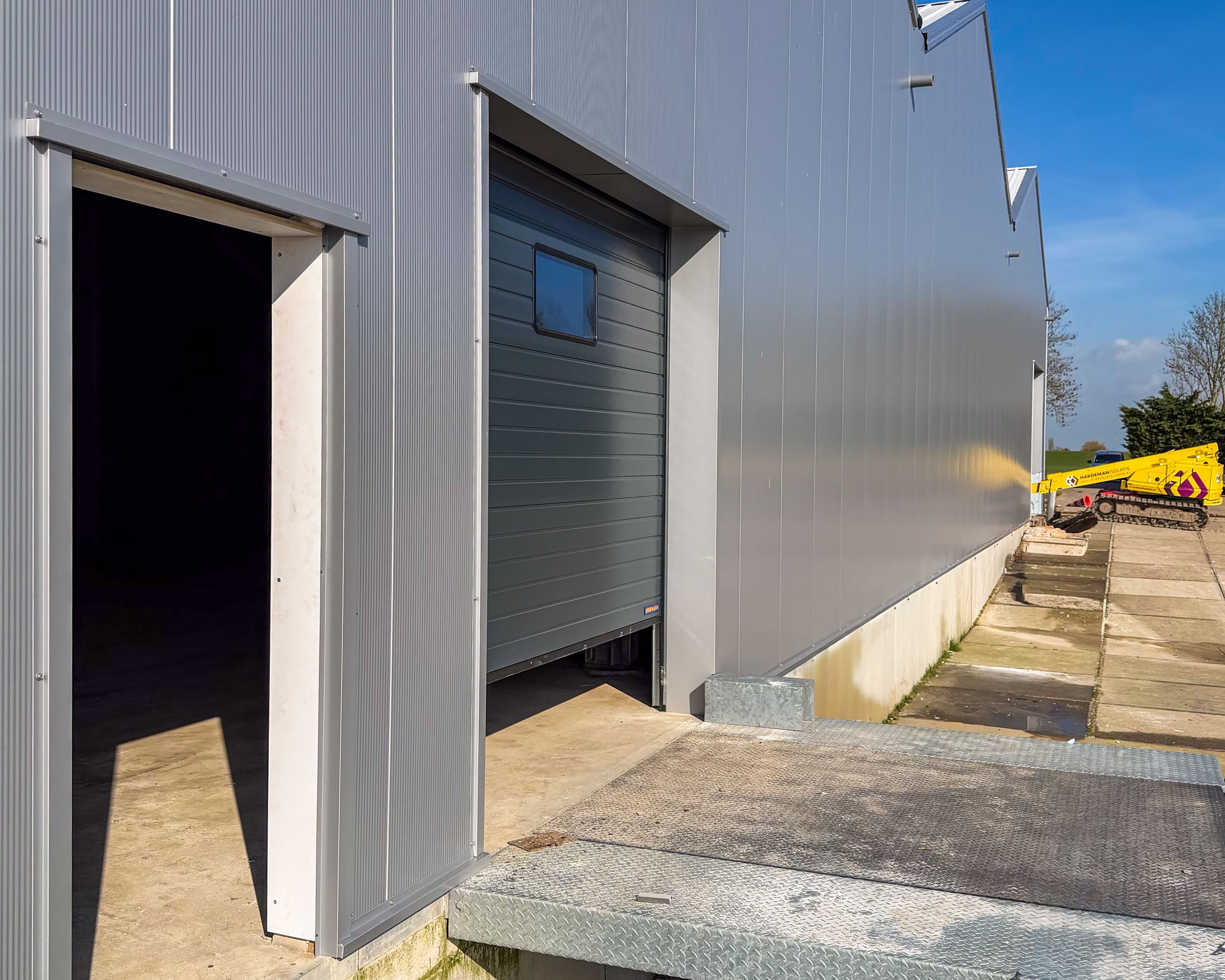 Gevel van bedrijfshallen Mijdrecht met sandwichpanelen en overheaddeuren
