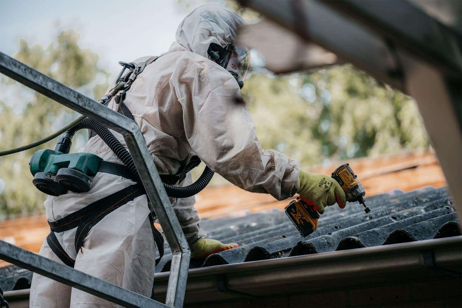 Gecertificeerde medewerker voert asbest sanering uit op golfplaten dak