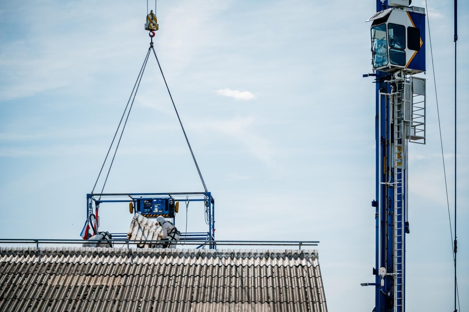 Asbest dak verwijderen met kraan tijdens sanering van agrarisch gebouw