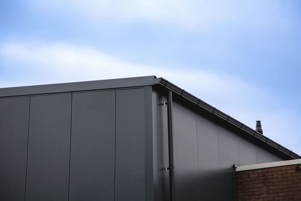 Nieuwe geïsoleerde dak- en gevelbeplating van een bedrijfshal aan de Hermesweg in Baarn, gerealiseerd door Hardeman Isolatie.