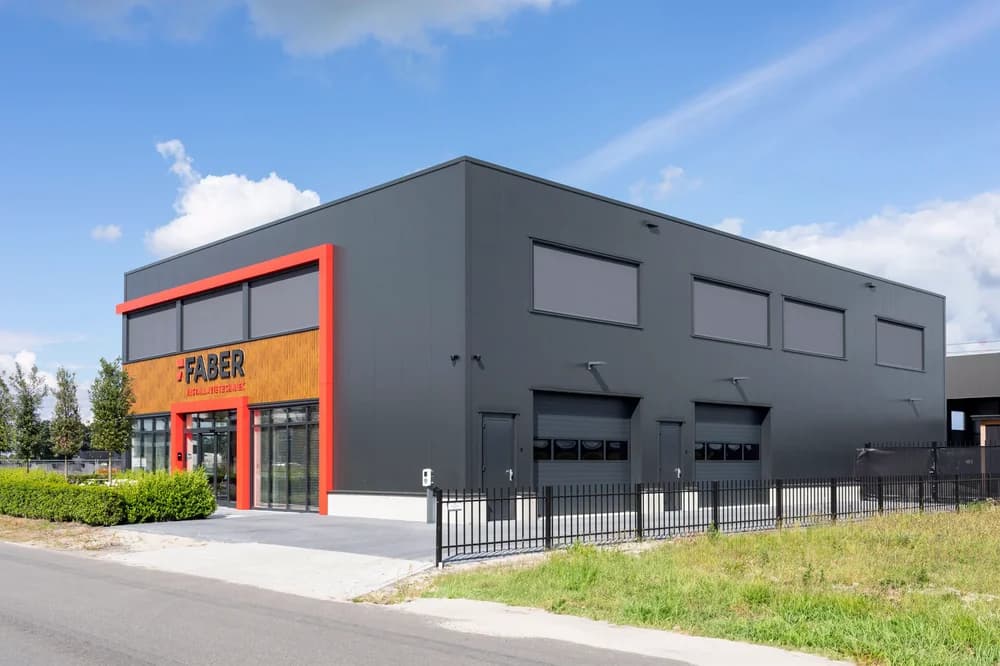 Overzicht van het nieuwe bedrijfspand van Faber Installatietechniek in Elburg met sandwichpanelen en composiet gevelkader
